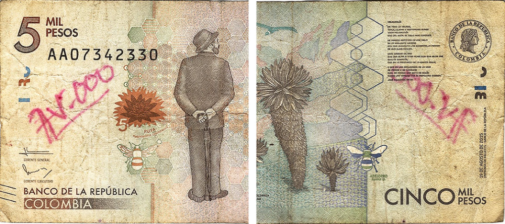 Fotografía de billete deteriorado por escrituras y dibujos.